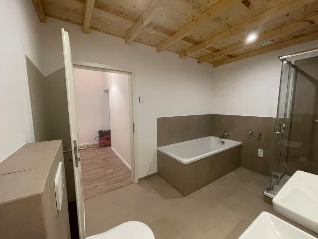 Eingebaute Badewanne und Glasdusche in einem komplett sanierten Bad in Hamburg.